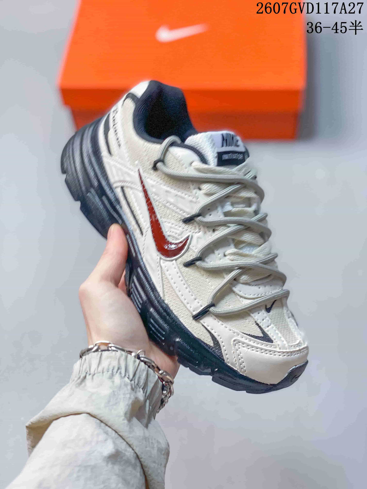 Angled side view of the Nike Initiator sneaker showing beige panels, red side accent, dark outsole and padded collar.