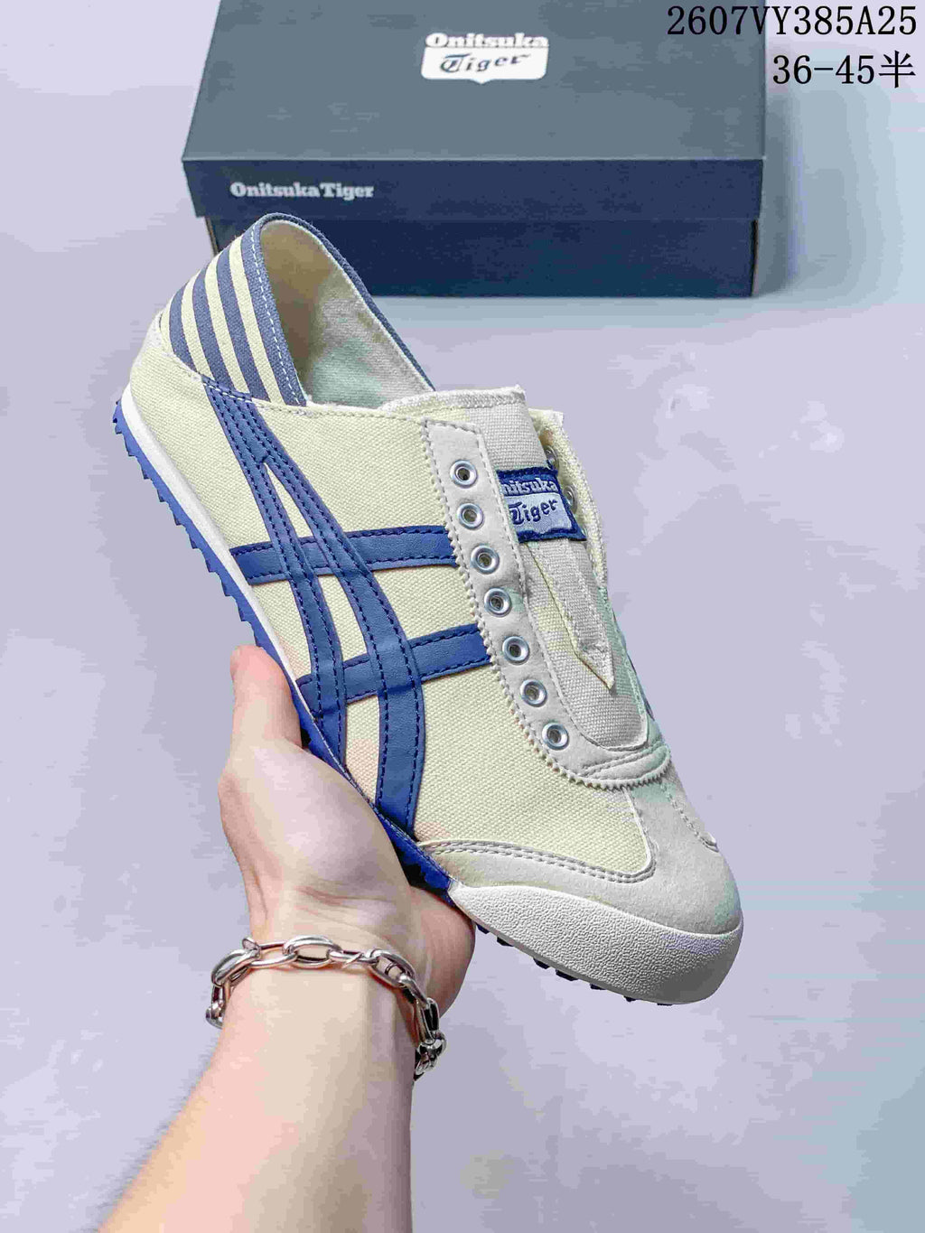 Cream slip-on sneaker with dark blue side stripes and a matching blue outsole detail.