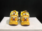 Rear view of the pair showing yellow heel padding, brown-and-yellow heel panels, and textured soles.