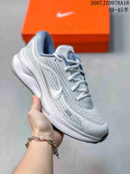 White Nike Journey Run sneaker with a white logo, patterned upper, and dark outsole detail.