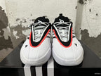 Front view showing the lace-up design and black, white, and red-orange detailing