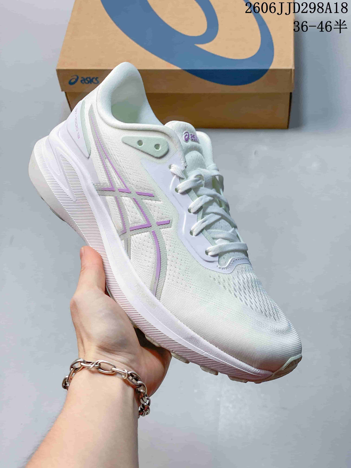 Angled side view of the white and lilac ASICS running shoe showing the branding, upper texture and outsole.