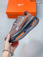 Side profile of the brown sneaker showing Pegasus branding, orange accents, and a sculpted black-and-orange midsole.