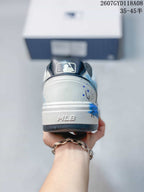 Rear view of the white sneaker showing blue splatter details, an MLB-marked heel section and dark outsole trim.