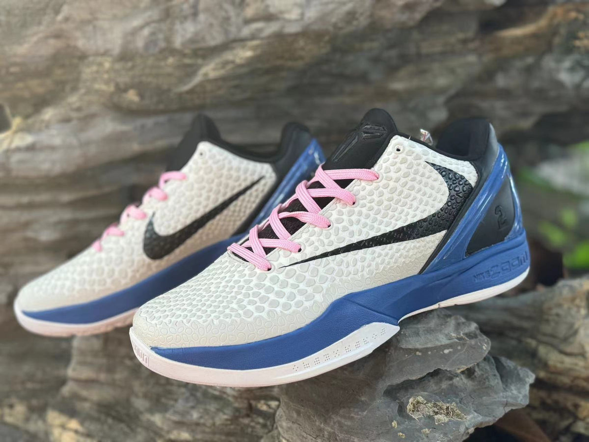 Close angled view of the textured upper, pink laces, and black Swoosh.