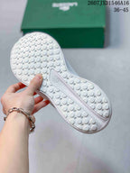Close view of the white textured outsole showing a circular traction pattern and central branding panel.