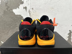 Rear view of black and yellow Kobe basketball shoes with red heel accents and signature graphics