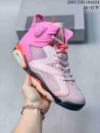 Angled side view of the pink high-top sneaker showing the perforated collar, white laces, raised side emblem and contrasting outsole.