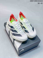 Pair of white Y-3 Adios Pro 4 sneakers with black side details, neon green accents, red collars, and a shoe box.