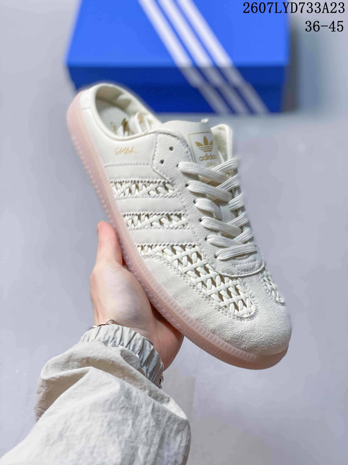 Close-up side view of an off-white adidas Samba OG mule-style sneaker with woven detailing and a translucent gum-colored outsole.