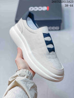 Angled side view of the light gray sneaker showing the navy crossover bands, heel branding, and raised white outsole.