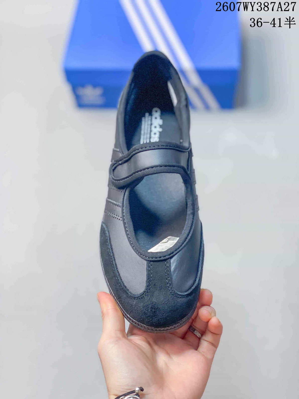 Top view of the black sneaker showing the rounded toe, tonal panels and Mary Jane-style strap.