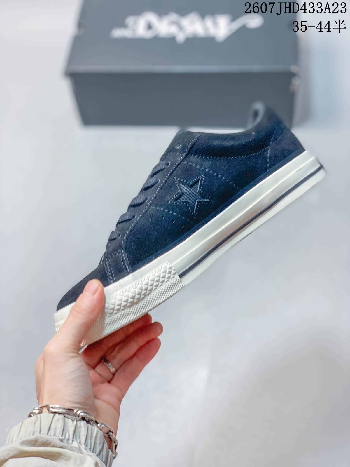 Side profile showing the navy upper, white embroidered detailing, and off-white rubber sole.