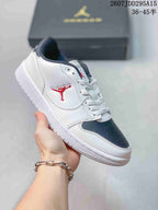 White and dark grey low-top Jordan sneaker held at an angle, with a dark toe panel and red side-panel logo.