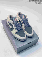 Pair of gray and navy low-top Jordan sneakers displayed on a shoe box, with the printed style code and size range visible above.