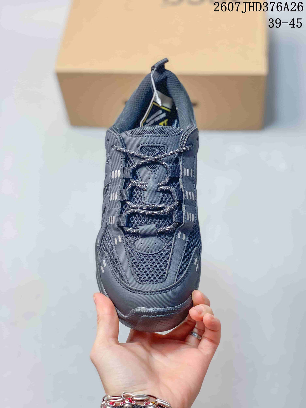 Front view of the dark gray lace-up sneaker showing the mesh toe area and contrasting accent details.