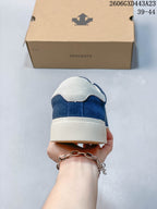 Rear view showing the cream heel panel and textured sole of the blue sneaker
