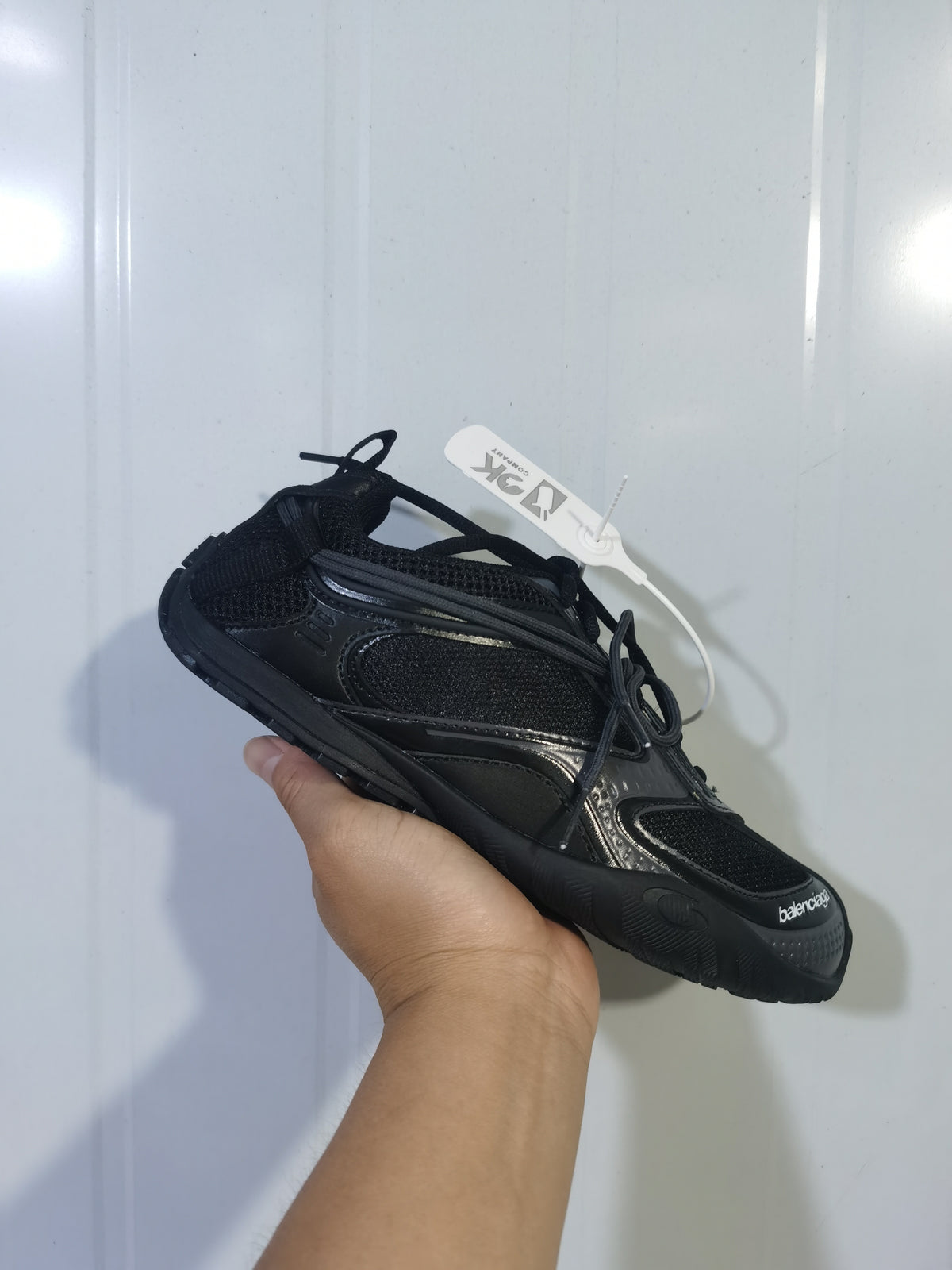 Angled front and side view of the black Balenciaga Radar sneaker, showing the mesh upper, tonal overlays, laces, and textured toe and outsole.
