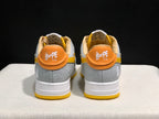 Rear view showing orange heel panels, BAPE STA branding, and grey embossed heel sections.