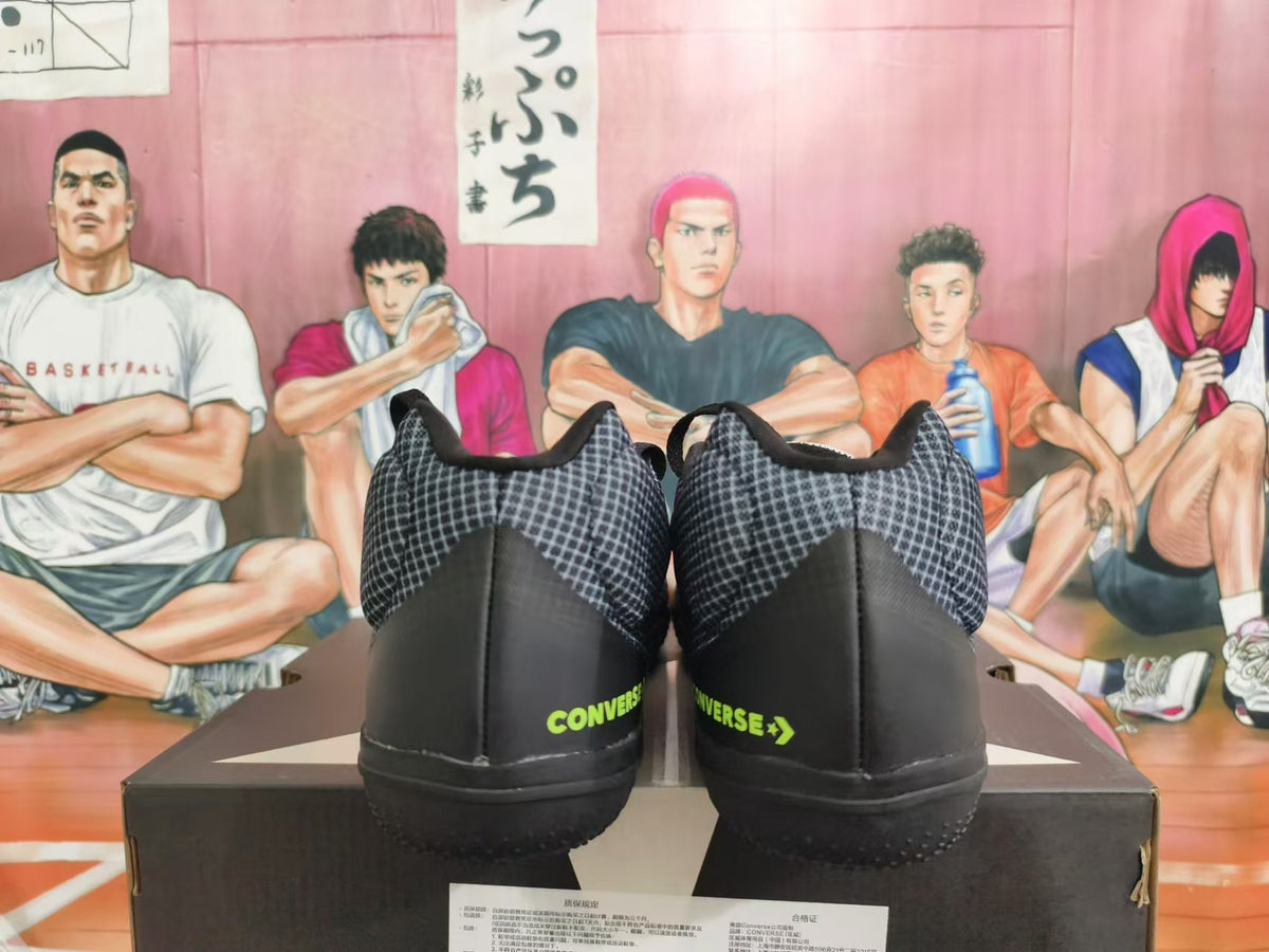 Rear view of black and gray Converse basketball shoes with bright green heel branding