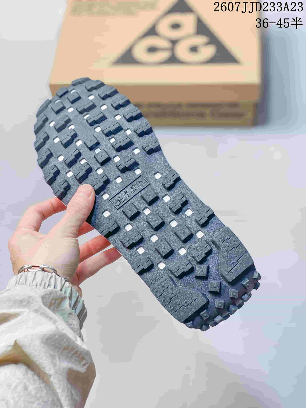 Close view of the dark lugged outsole showing its block-pattern tread.