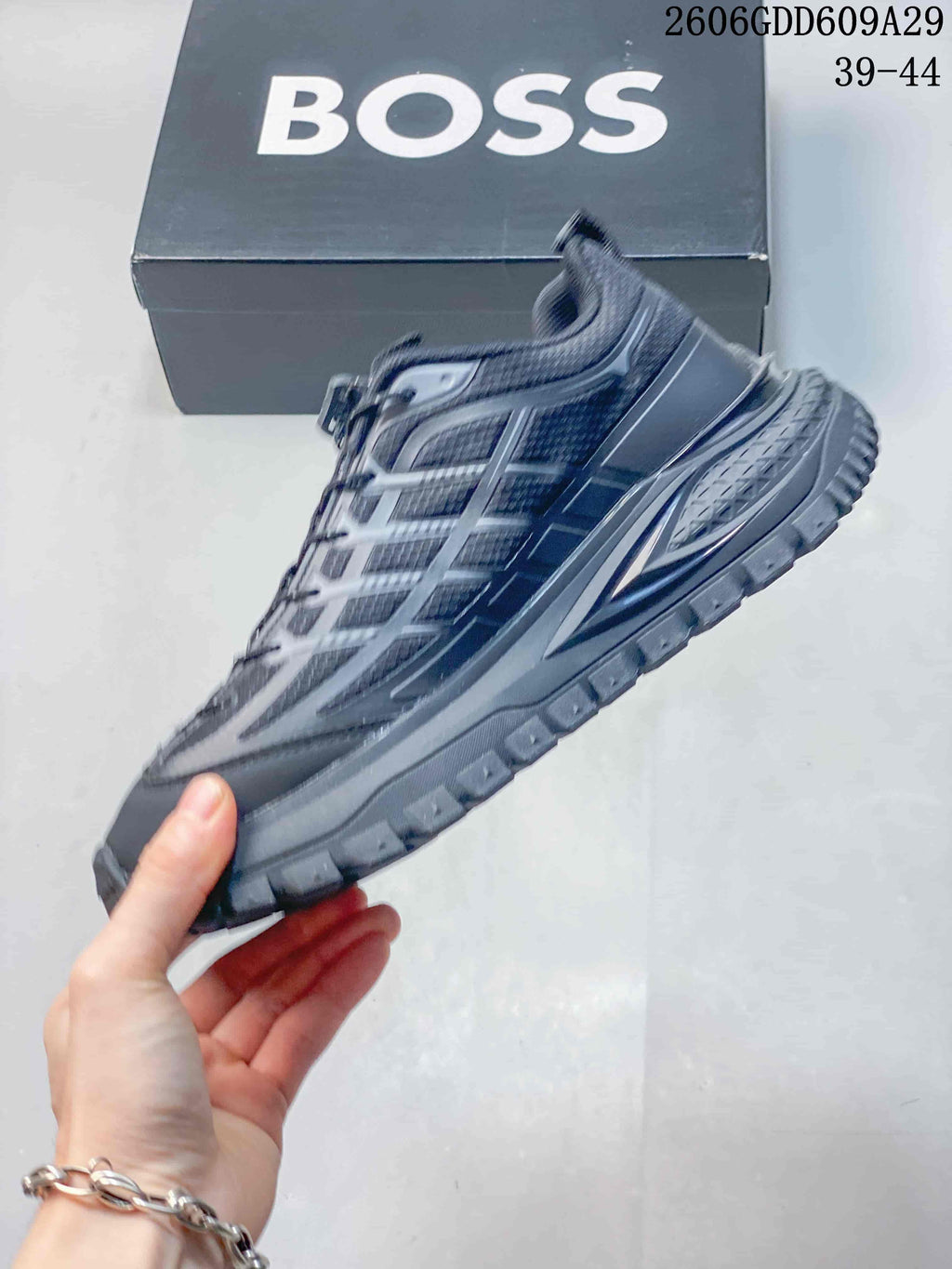 Side profile of a gray lace-up sneaker with layered panels and a chunky sole.