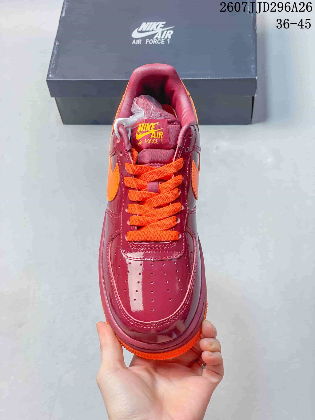 Top view showing the perforated toe box, orange laces, burgundy tongue, and Nike Air Force 1 tongue branding.