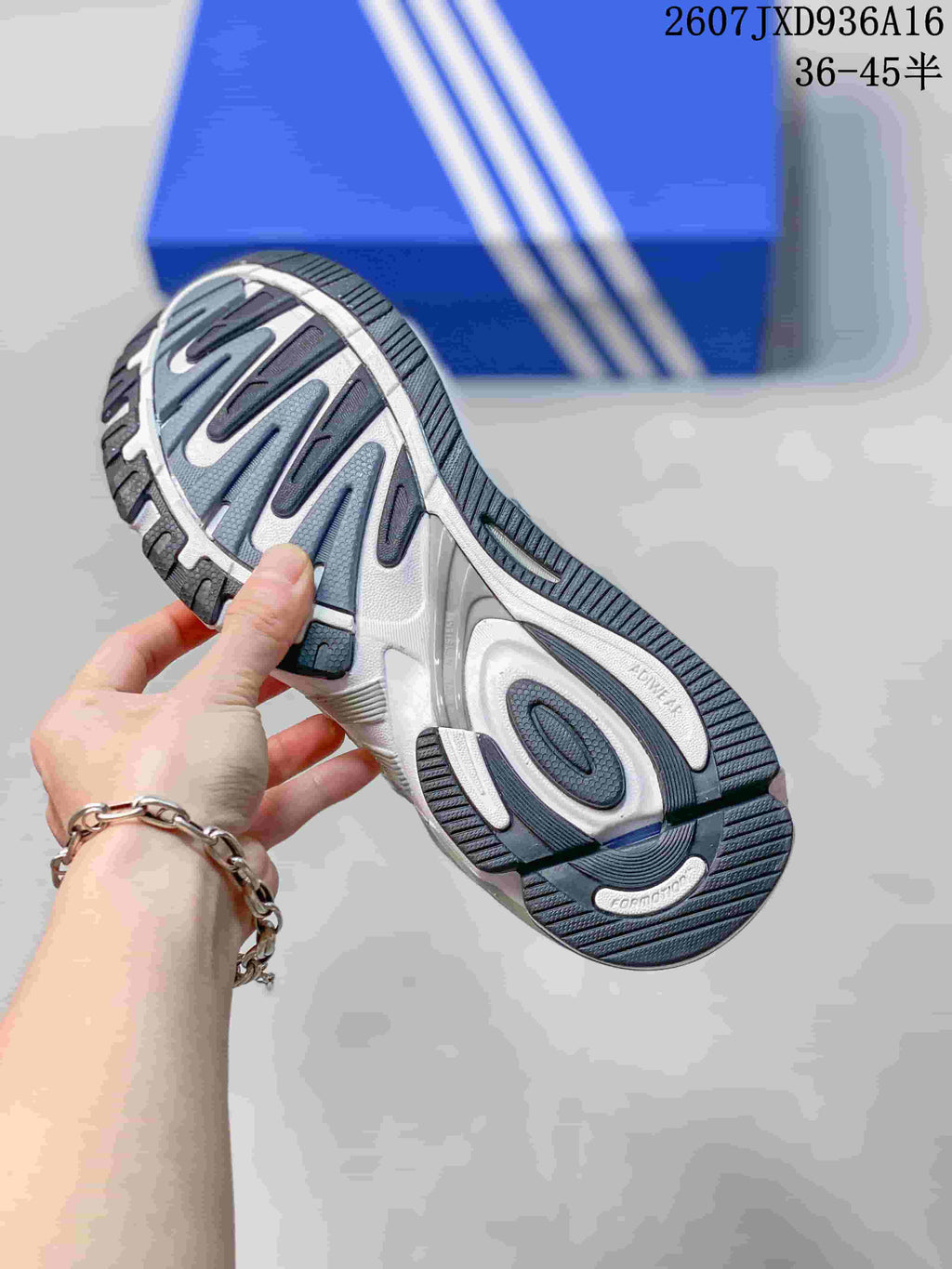 Close view of the sneaker outsole showing a dark blue and gray tread pattern.