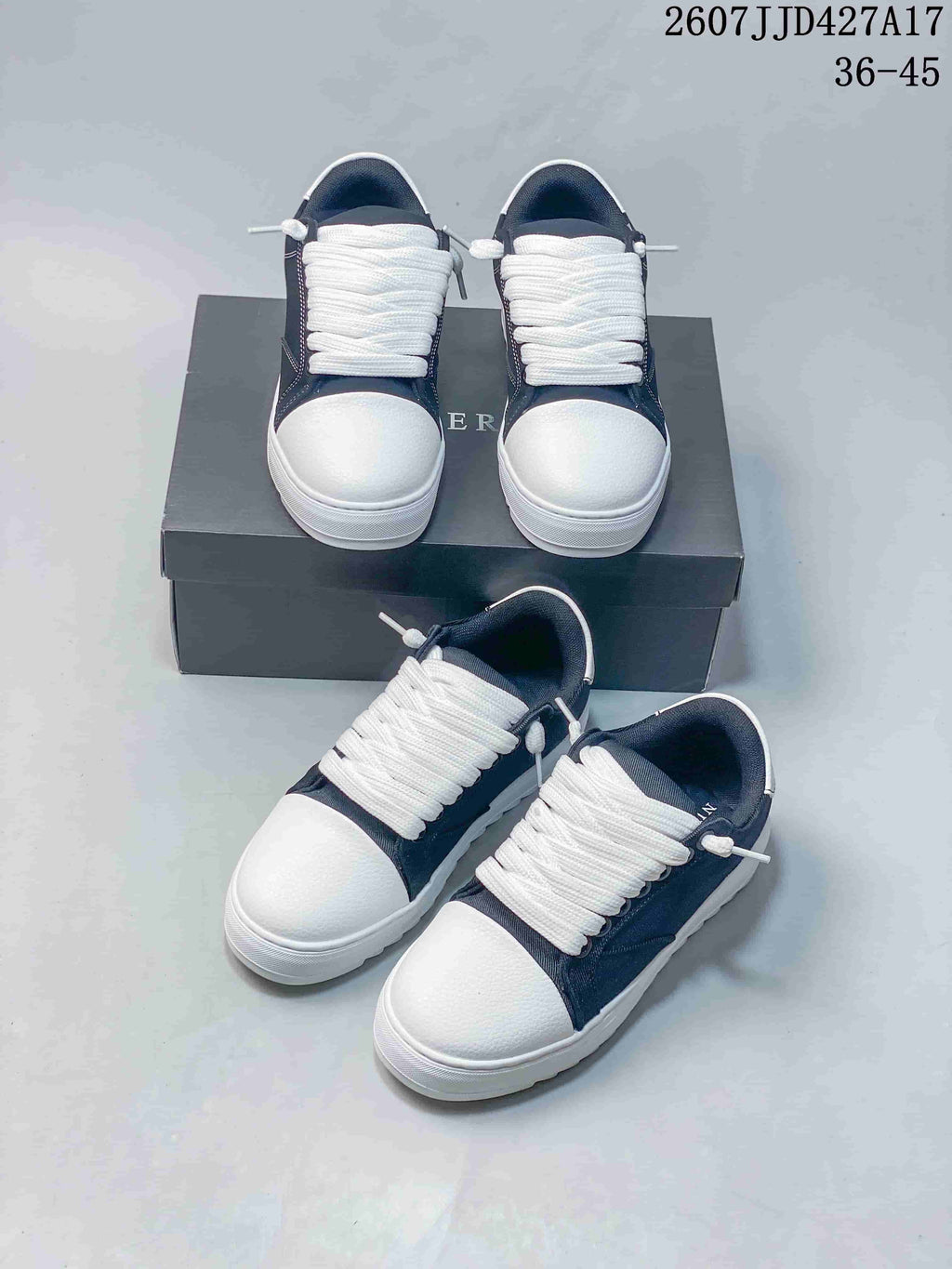 Multiple views of the navy and white sneaker pair arranged on and beside a dark shoe box.