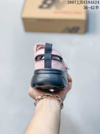 Rear view showing the dark heel section, pull tab, pink upper, and New Balance branding.