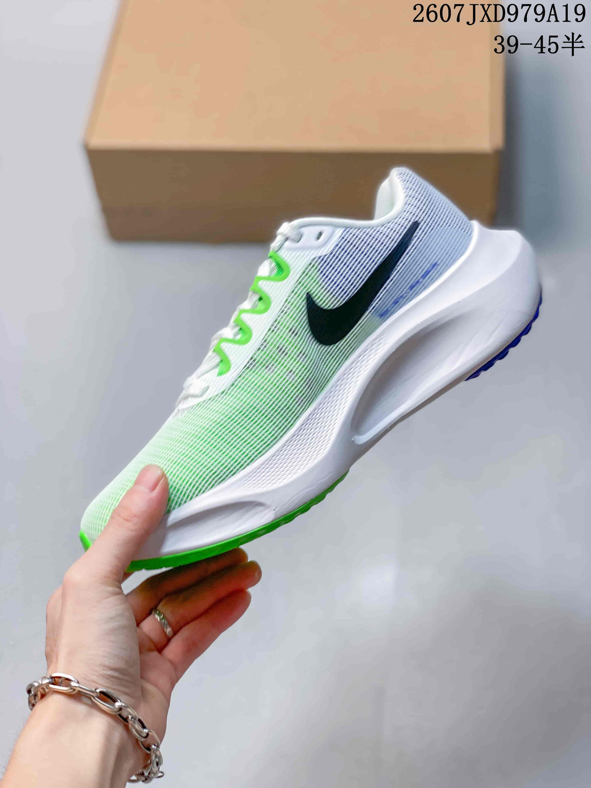 Side view of a white Nike running sneaker with black branding, green upper accents and a sculpted white midsole.