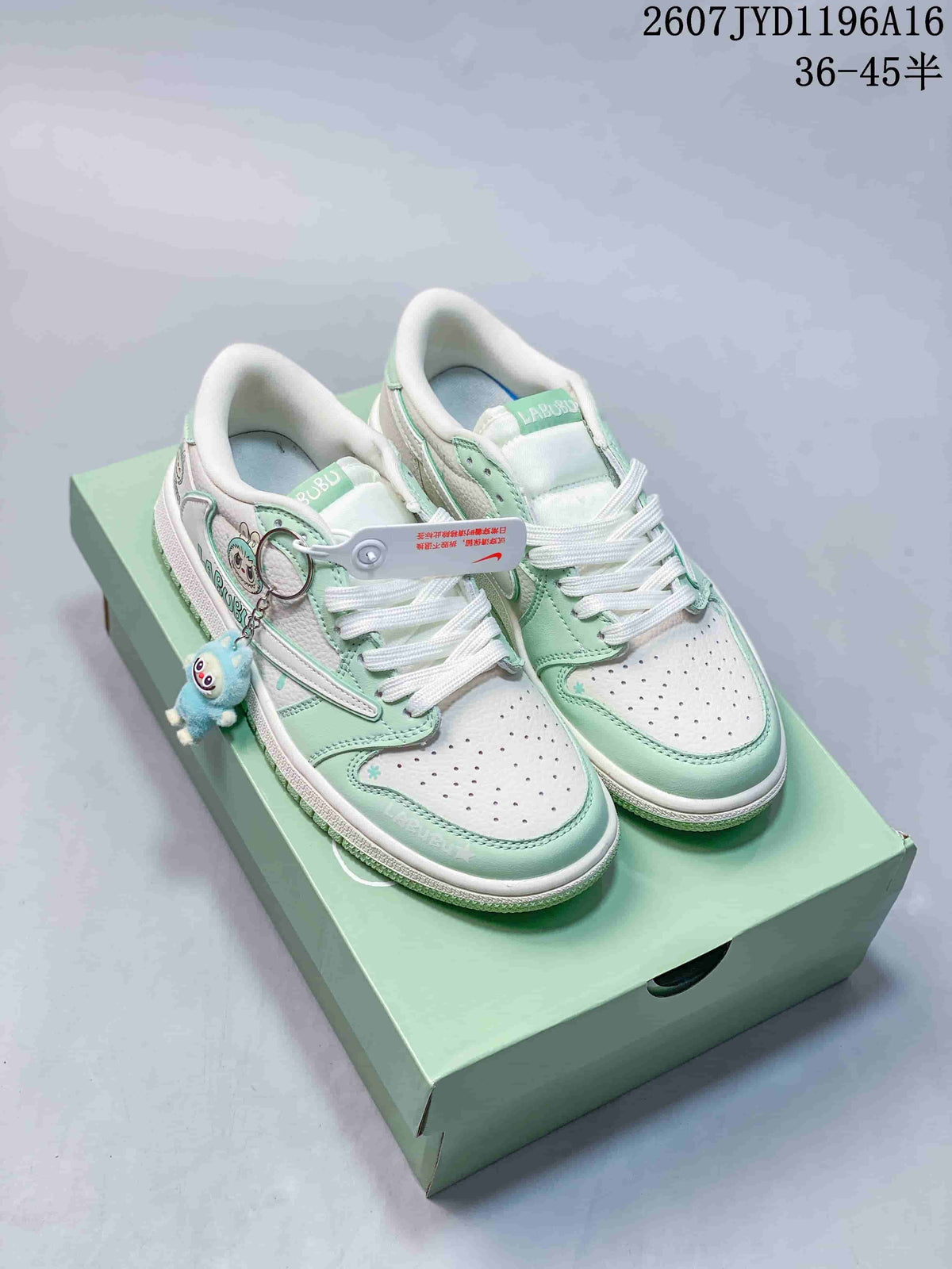 Pair of mint green and white Jordan low-top sneakers on a matching green box, with Labubu-themed details and a blue character charm.