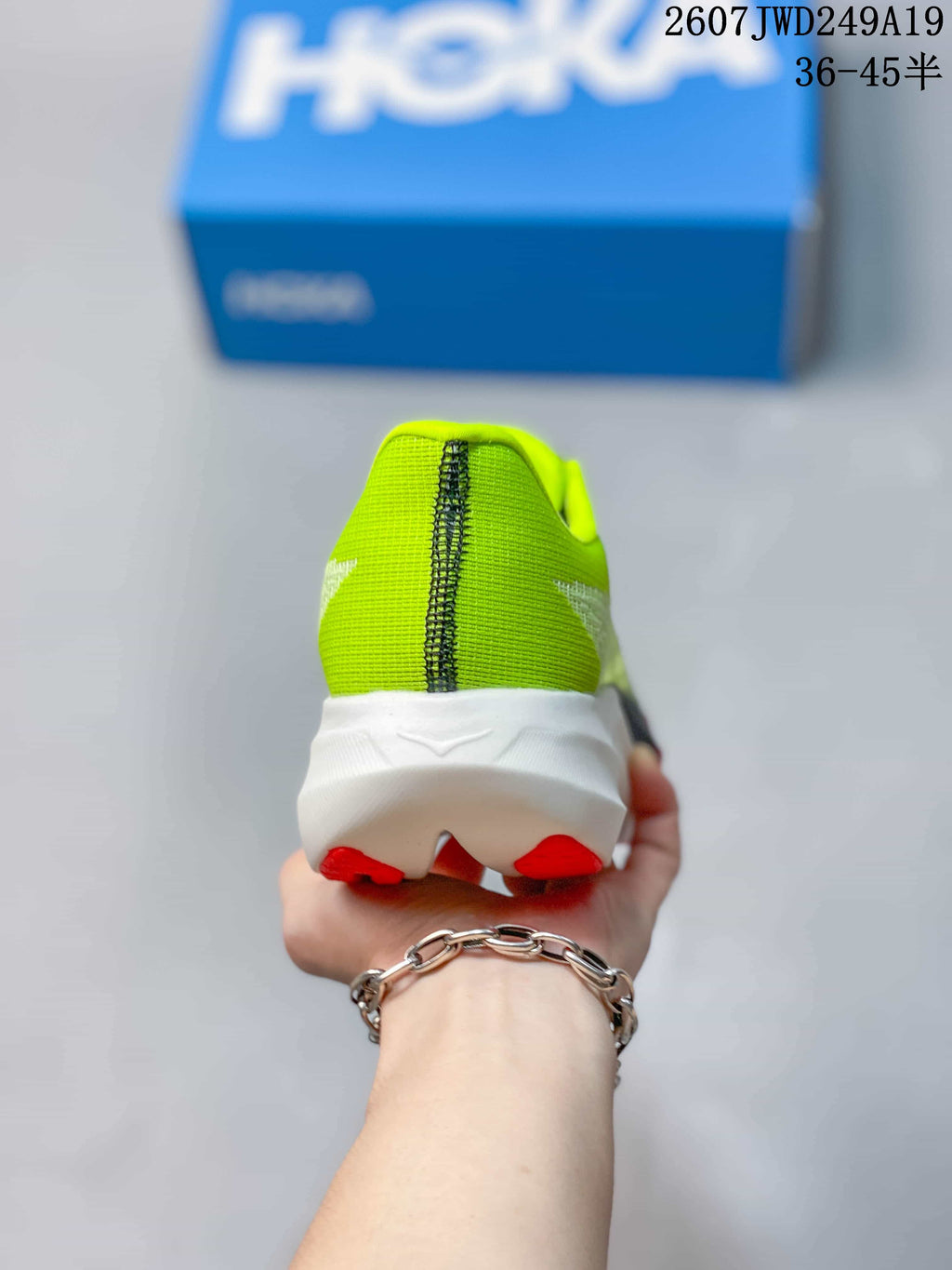 Rear view showing the green heel, central stitching, white midsole, and red outsole sections.