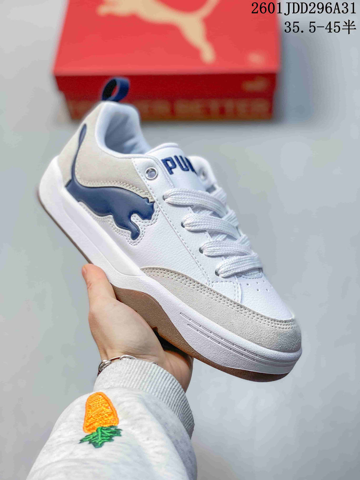 Angled side view of the white sneaker with blue branding, gray toe detailing, and raised sole.