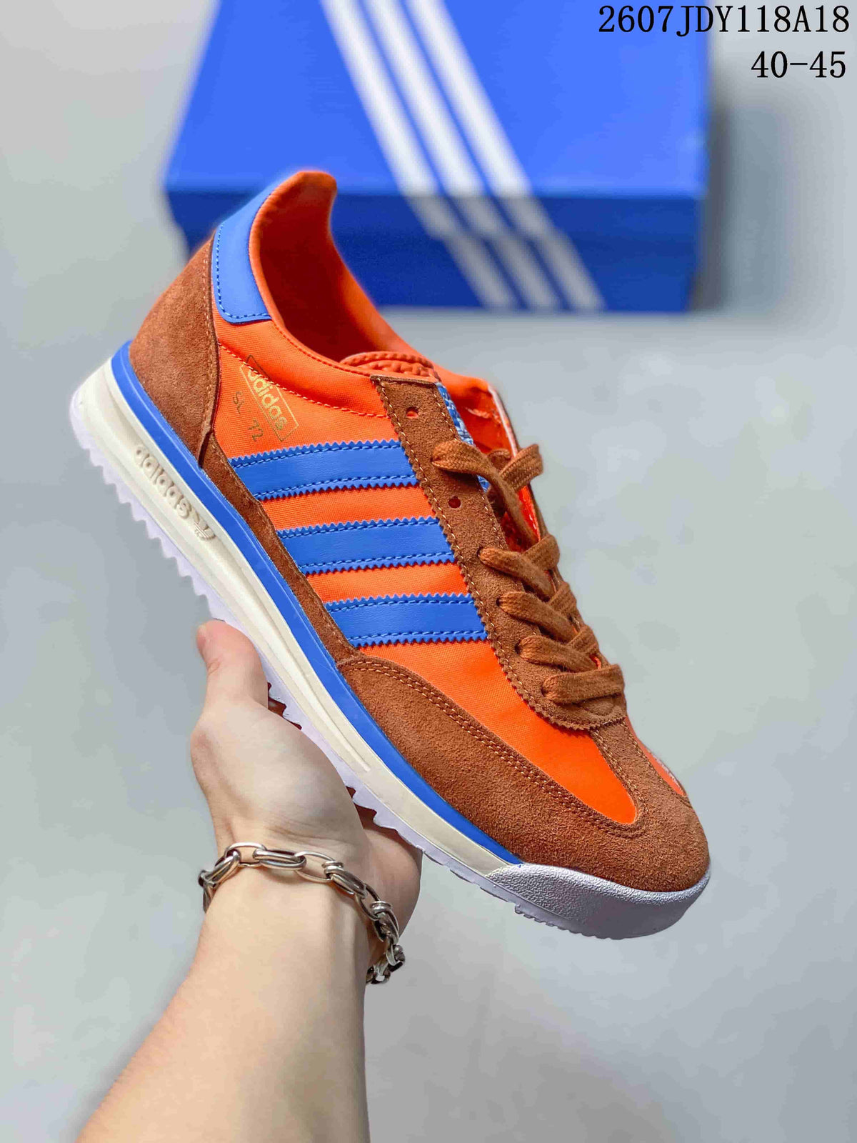 Orange and brown adidas SL 72 sneaker with bright blue stripes.