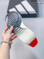 Underside view showing the patterned outsole, elongated traction grooves, and red heel section.
