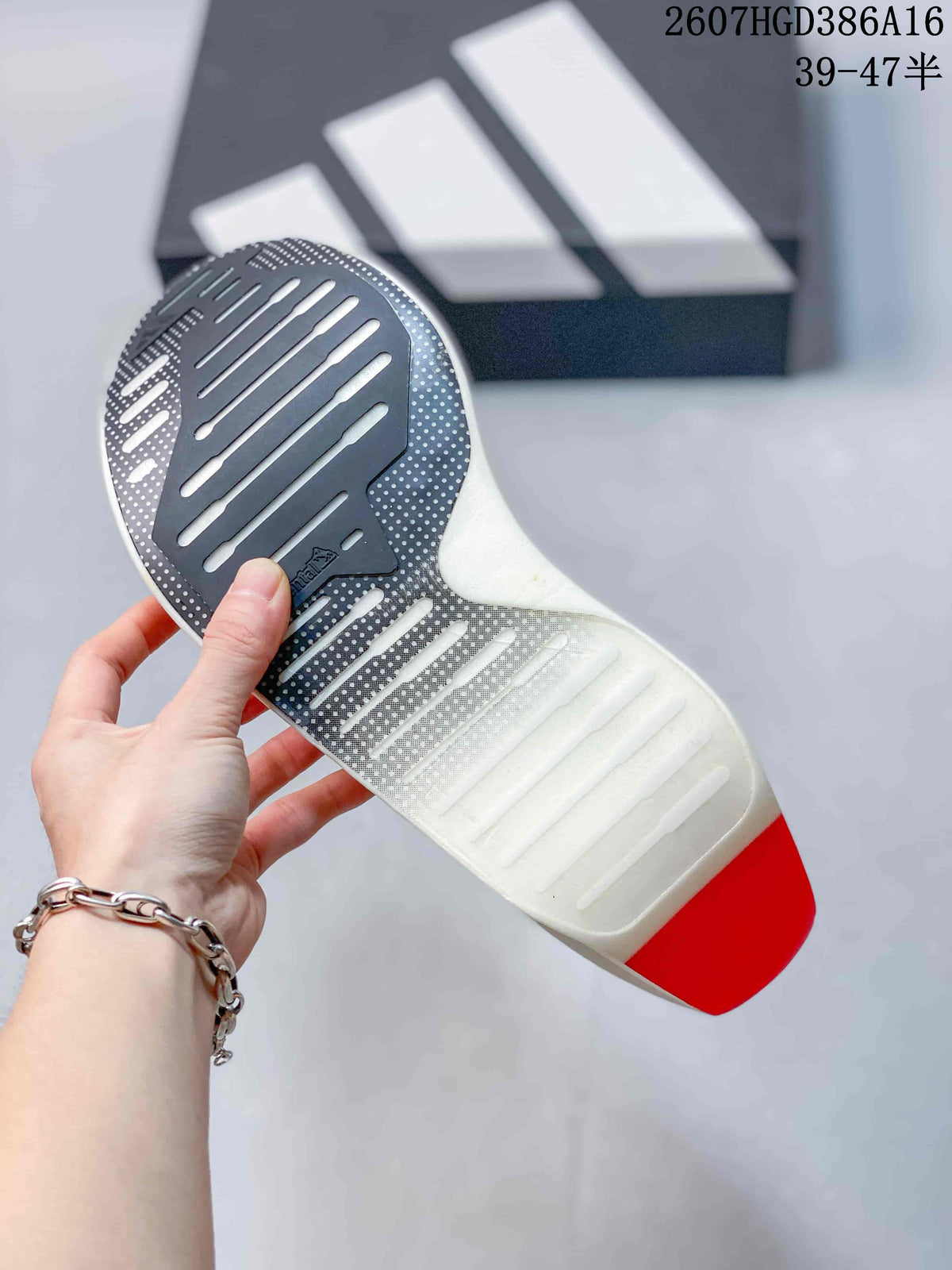 Underside view showing the patterned outsole, elongated traction grooves, and red heel section.