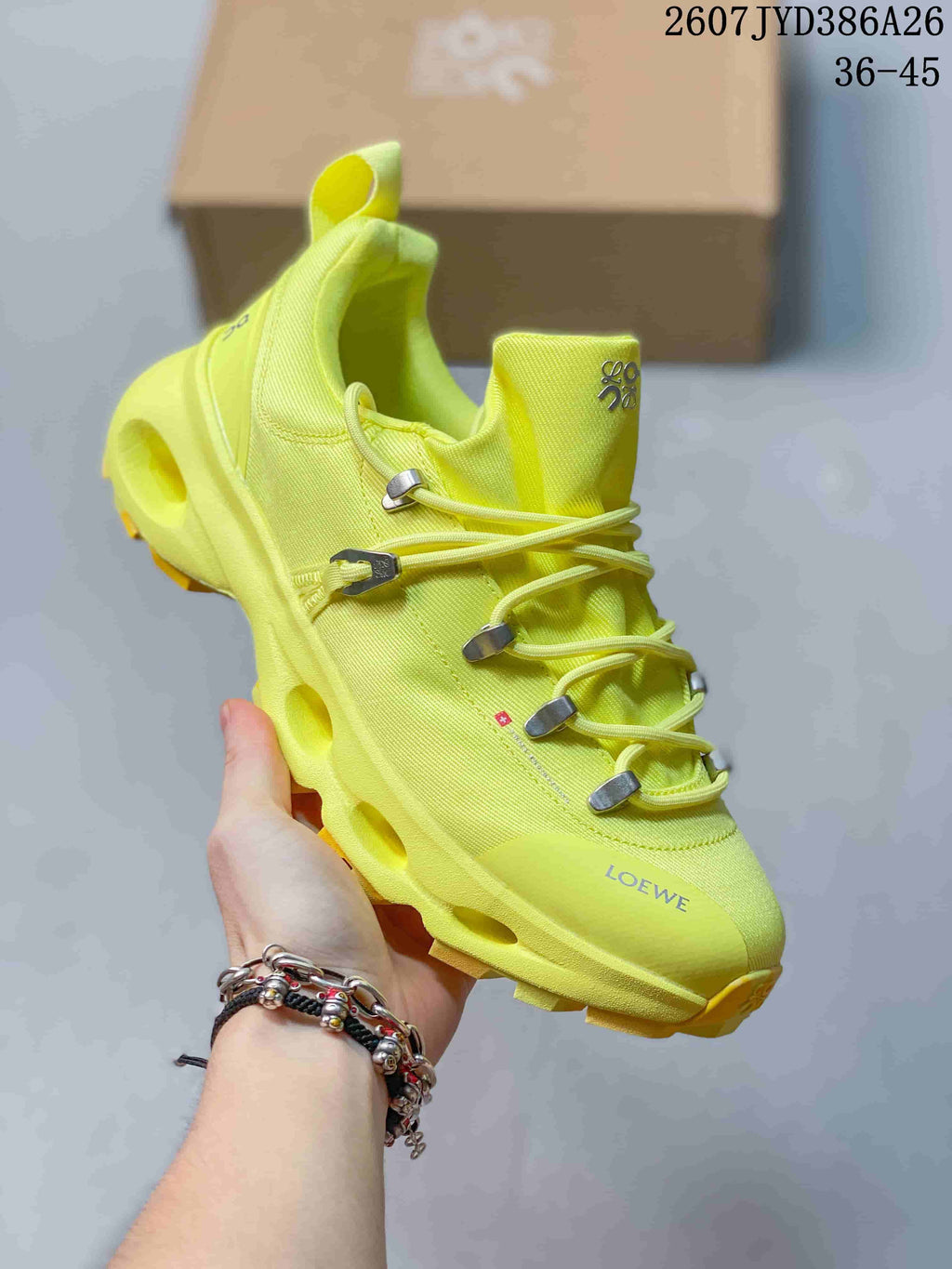 Angled side view of the neon yellow On x LOEWE sneaker showing the lace hardware, heel cushioning channels, and treaded outsole.