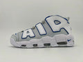 Side view of a white and gray Nike Air More Uptempo sneaker with blue-trimmed AIR lettering and visible sole cushioning
