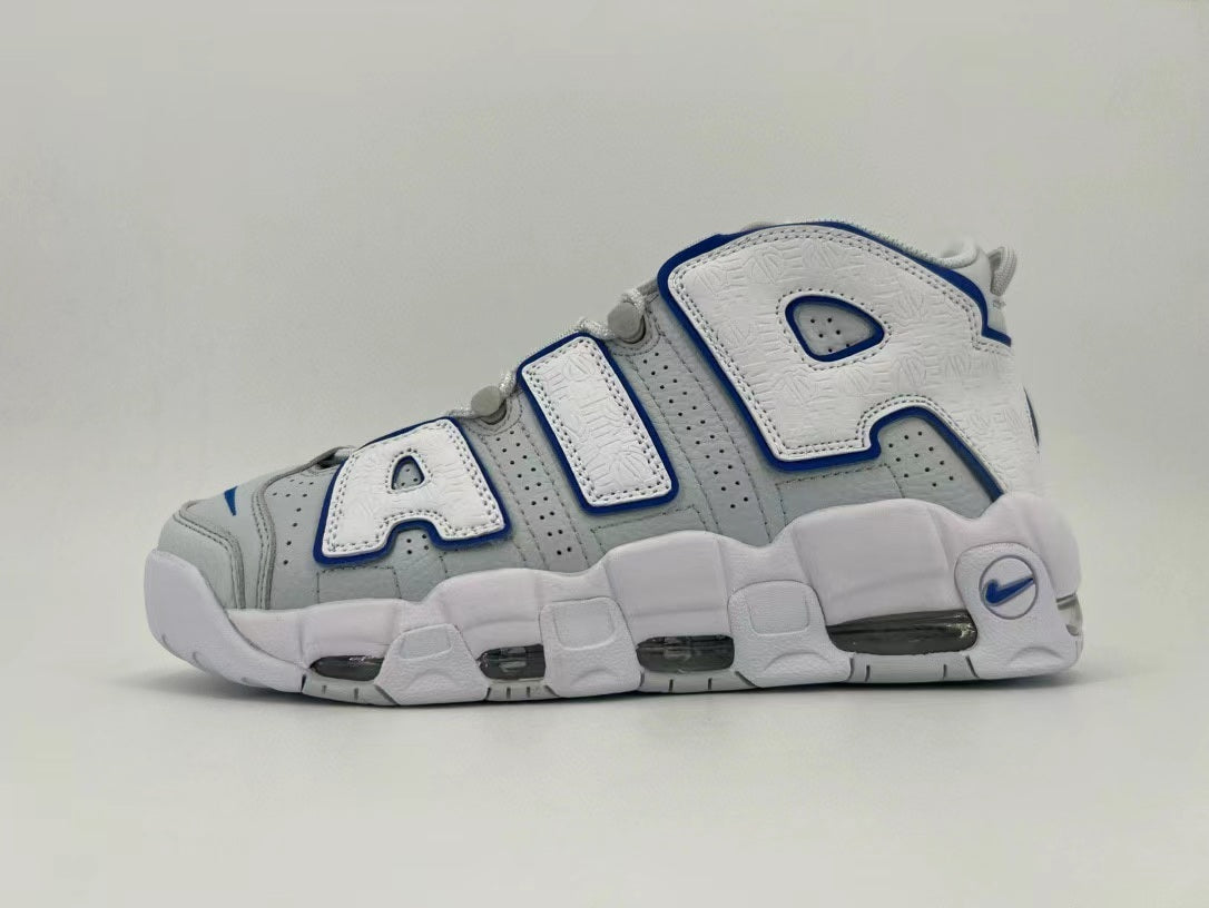 Side view of a white and gray Nike Air More Uptempo sneaker with blue-trimmed AIR lettering and visible sole cushioning