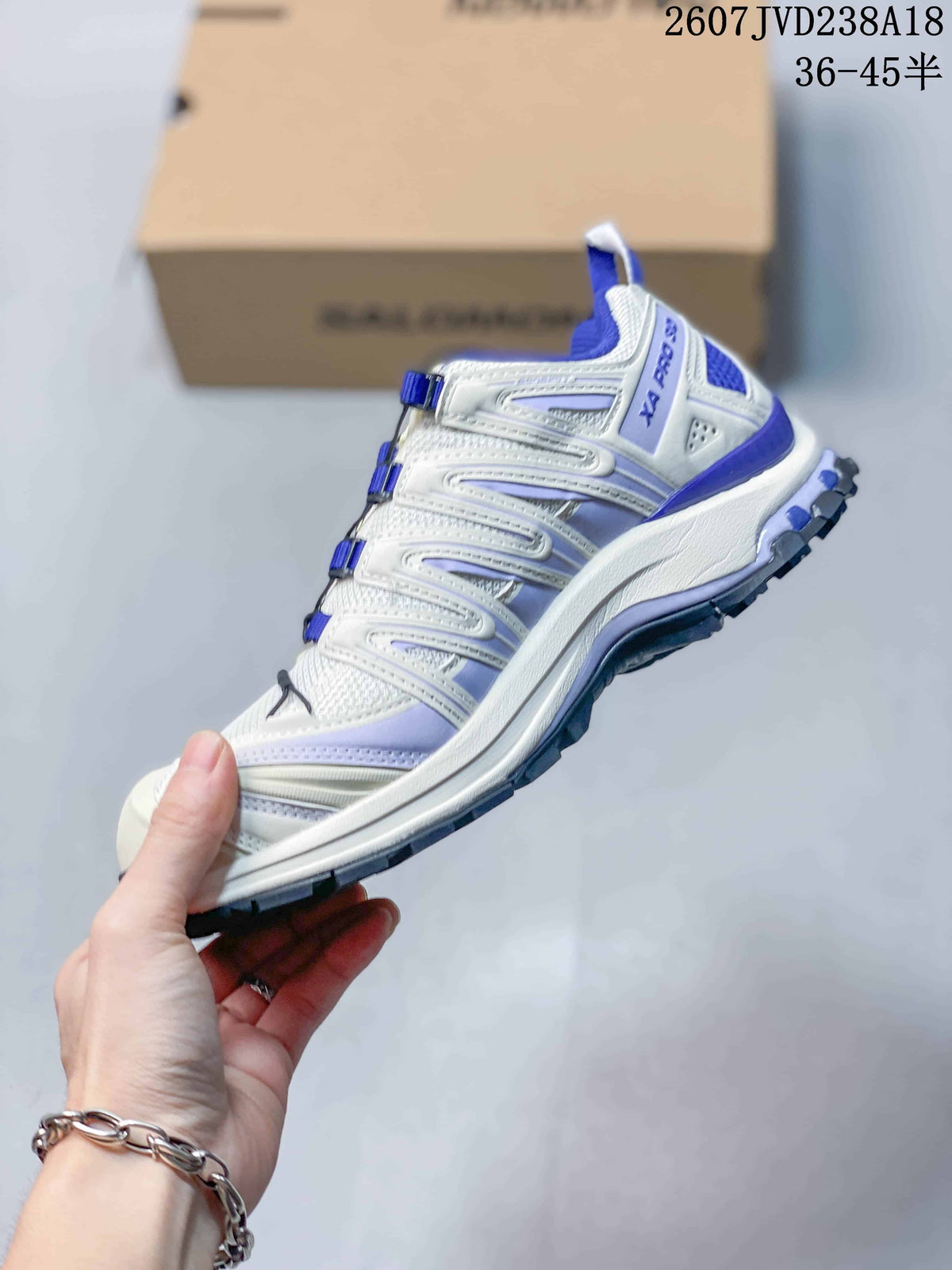 Side view of a white and blue Salomon XA Pro 3D V9 shoe showing the layered upper and rugged outsole.