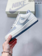 Side view showing the white Nike Swoosh, patterned side panel, blue-grey toe area and low-top construction.