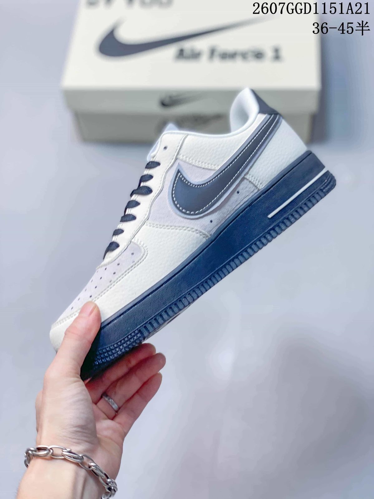 Side view highlighting the white upper, navy Swoosh branding, navy midsole area, and low-top profile.