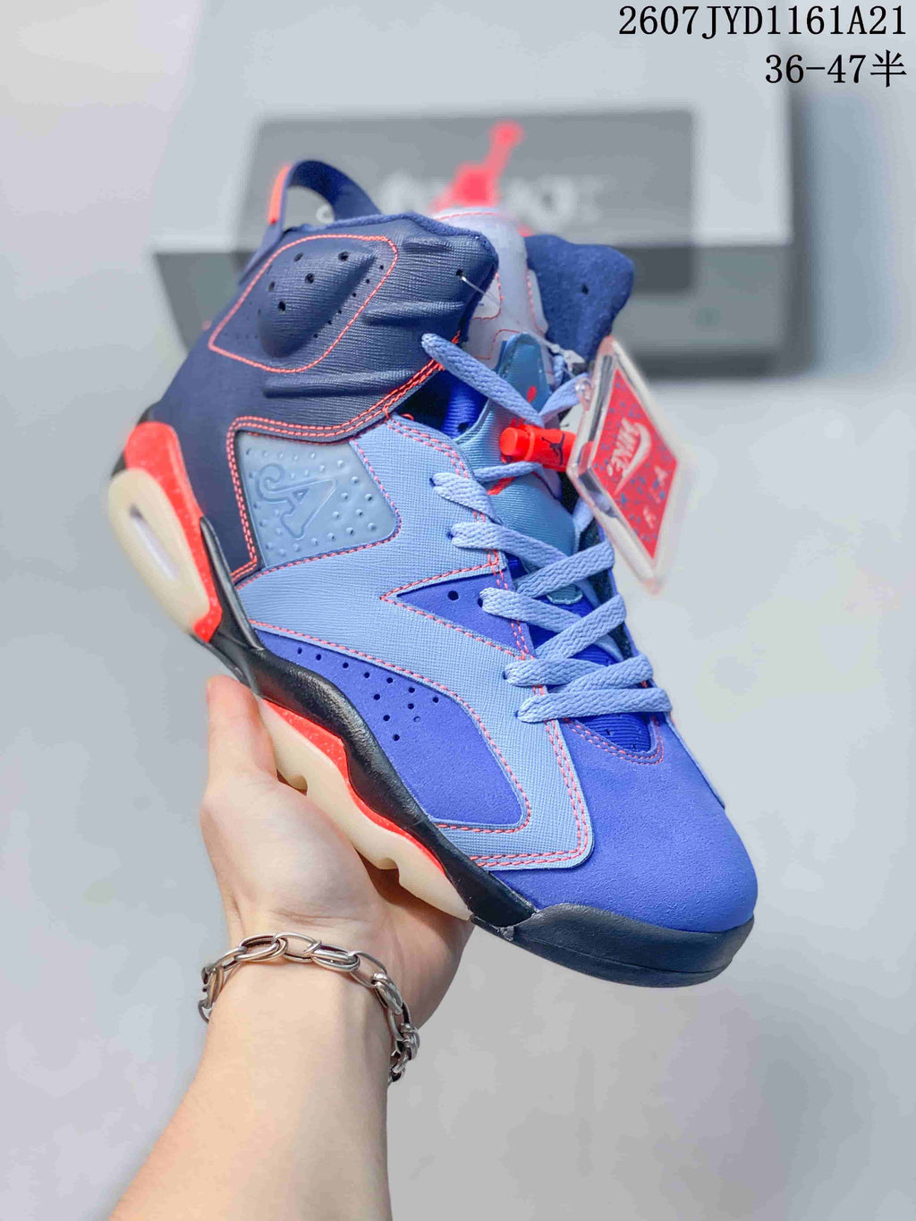 Angled side view of the blue and red high-top sneaker showing its lace-up construction, perforated panels, heel loop, and outsole.