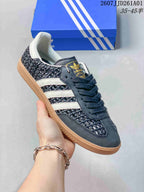 Angled view of the dark Samba-style sneaker with woven-look panels