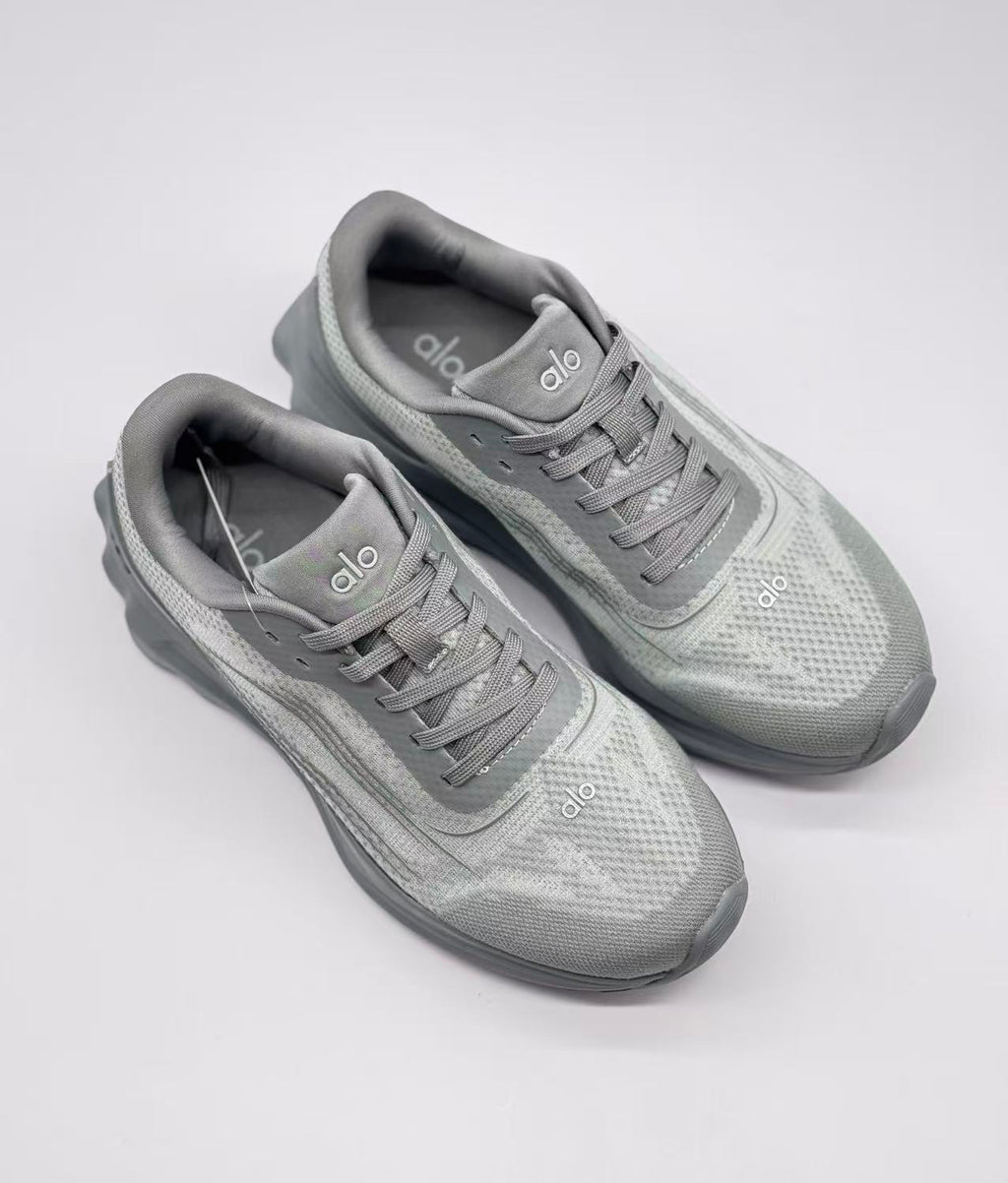 Top view of a pair of gray Alo Runner sneakers showing the lace arrangement, padded collars, and textured uppers.