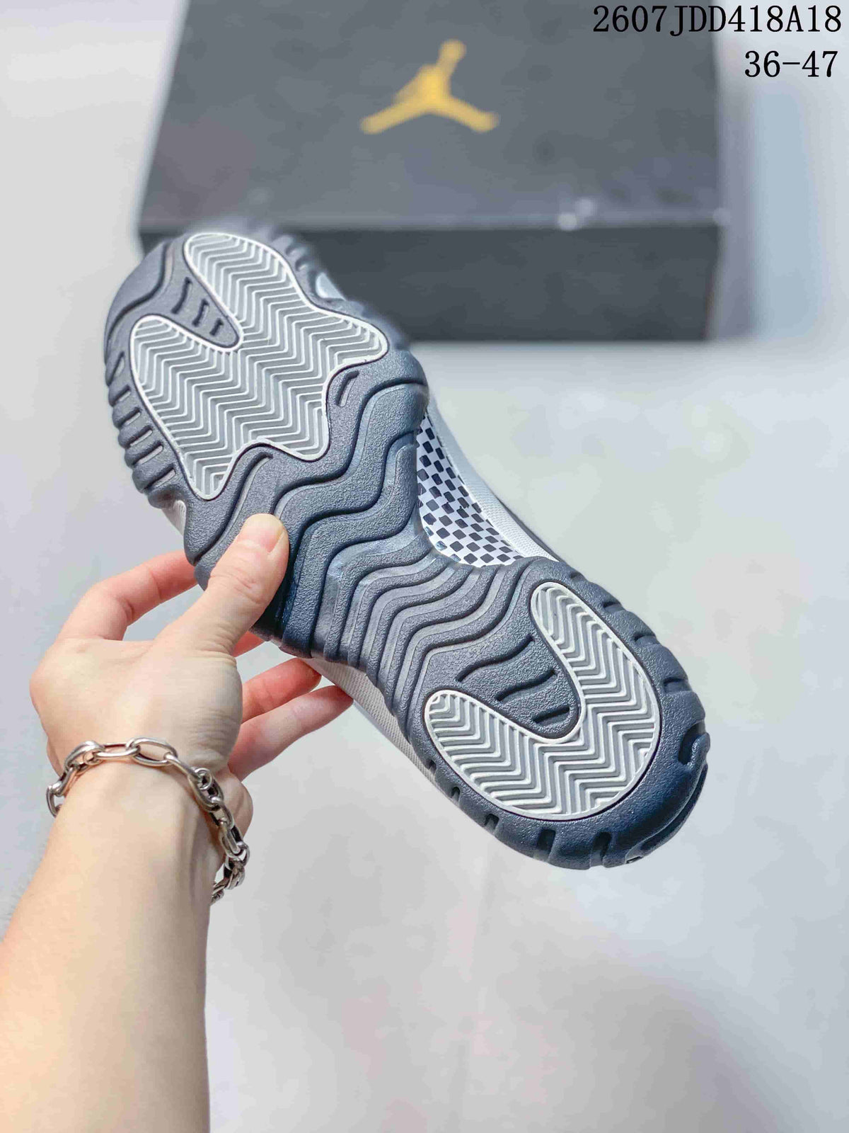 Underside view of the sneaker showing the grey patterned rubber outsole and textured tread.