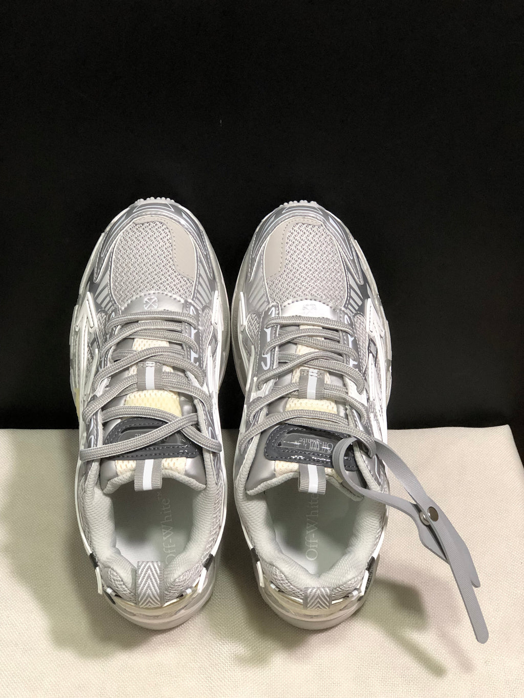 Top-down view showing the lace-up construction, padded collars, tongue details, and grey-white upper panels.