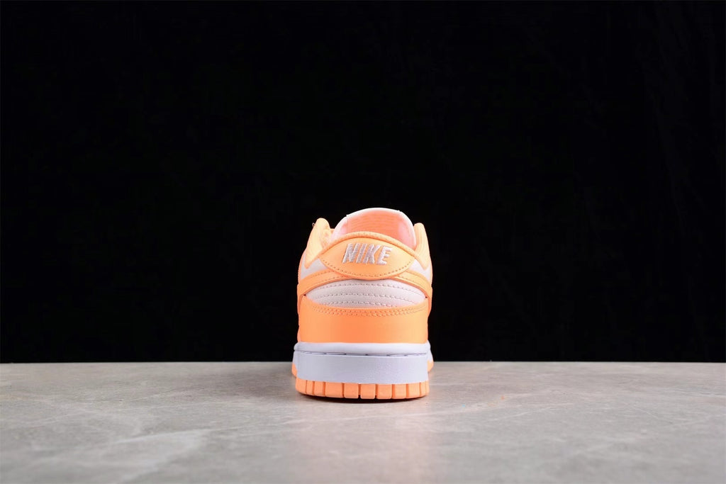 Rear view showing the orange heel, light gray heel panel, Nike branding, and rubber outsole.