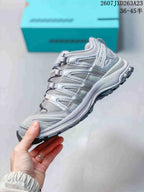 Side profile of the alloy gray and silver Salomon XA Pro 3D sneaker showing its layered upper, cord fastening system, low-top shape, and textured outsole.